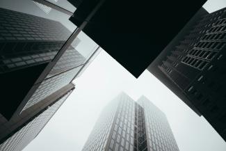 a group of tall buildings towering over a city by Louis Droege courtesy of Unsplash.